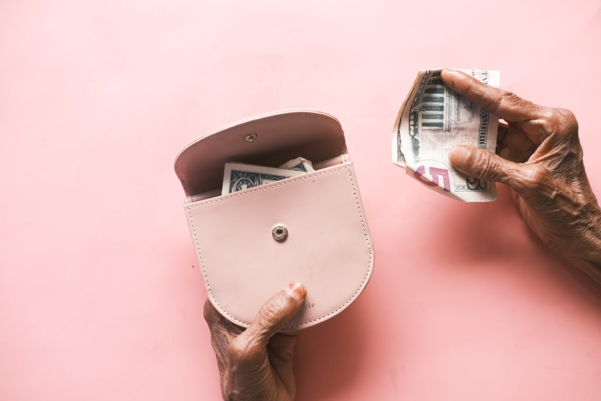 Elderly hand pulling money.