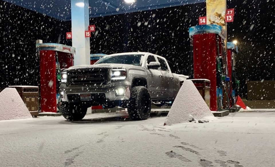GMC truck in snow at the gas pump.
