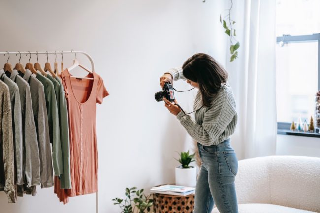 Woman taking photos of clothing for her side hustle..