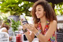 young woman using phone and credit card