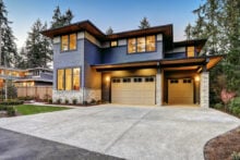 Luxurious new construction home in Bellevue, WA. Modern style home boasts two car garage framed by blue siding and natural stone wall trim. Northwest, USA