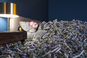 Man sleeping in a bed covered with lots of money