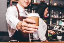 Barista handing out a coffee at a coffee shop