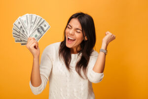 Excited woman holding cash in her hand