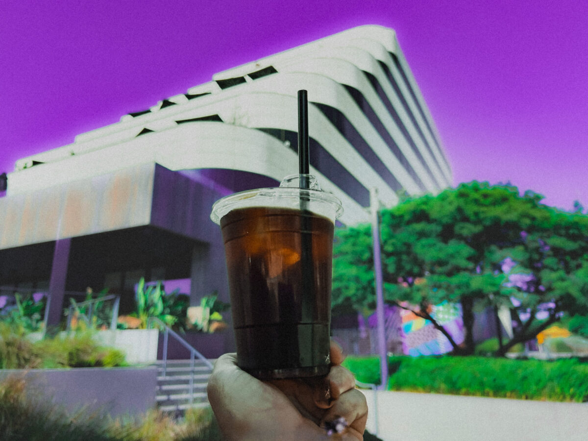 Office worker holding ice coffee outside an office