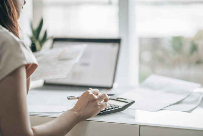 Woman doing paperwork and using a calculator