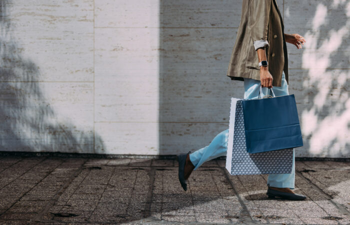 Woman Walking With Shopping Bags on City Street