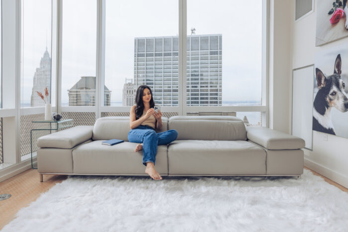 Hispanic woman spending a day at home relaxing in the living room and taking some time for herself.