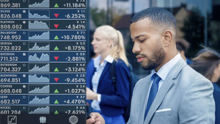 Businessman using trading app on his smart phone while walking outdoors.