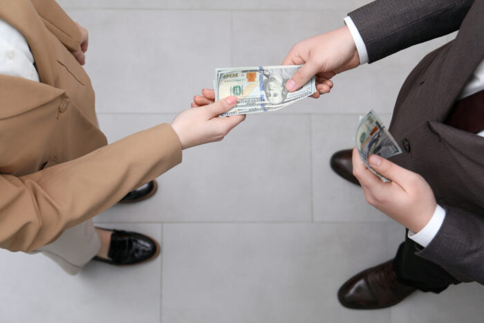 Man giving money to woman indoors, above view. Currency exchange