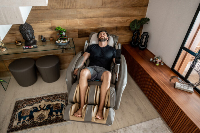 Mid adult man sleeping on a massage chair at home