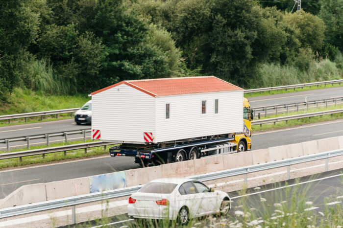 Truck on a highway carrying a prefab house