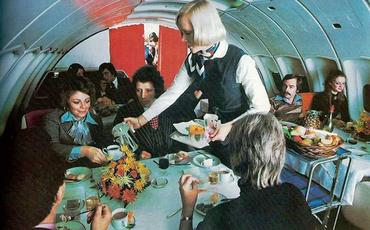 People being served coffee in first class in the 1970s