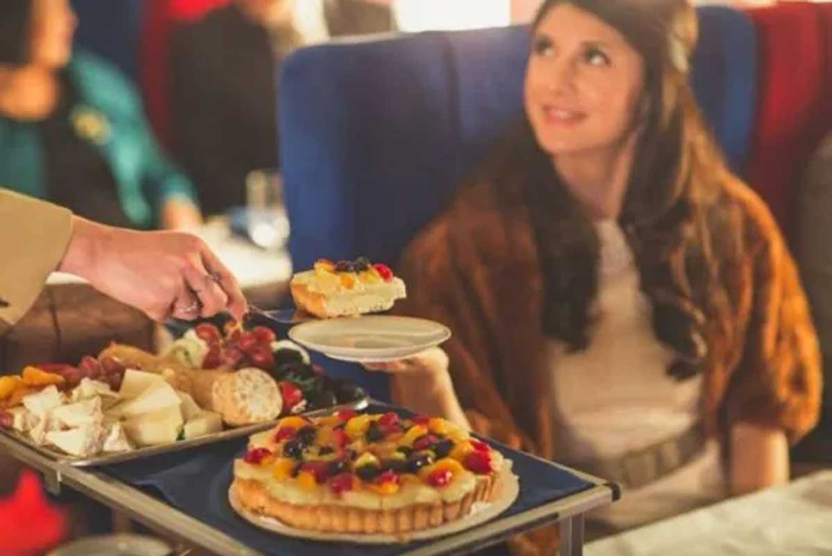 Woman on a plane being served dessert from a tray