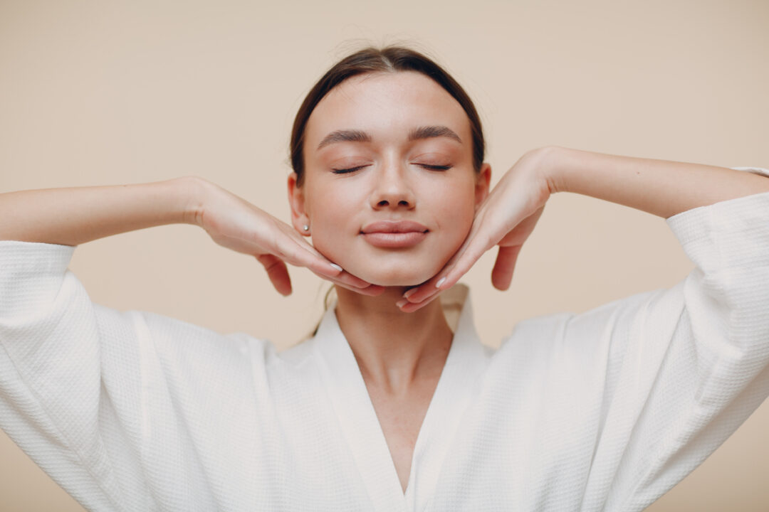 Young woman doing face building facial gymnastics self massage and rejuvenating exercises