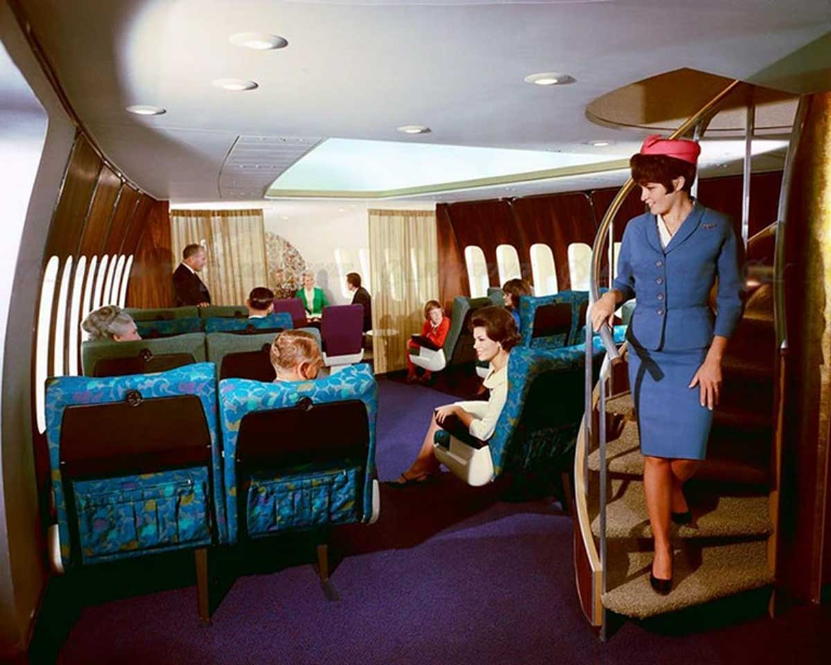 Flight attendant walking downstairs on a flight in the early 70s