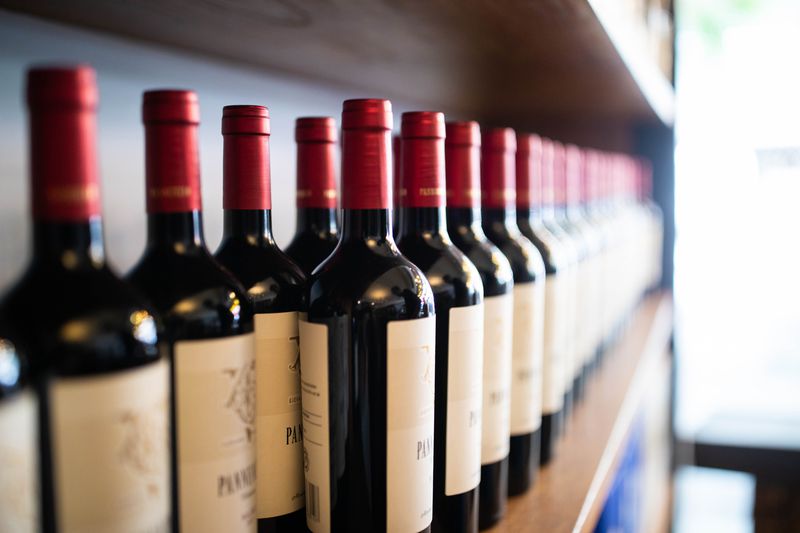 Wine bottles on shelf at a winery. Wine bottles in wooden stand on display at store.