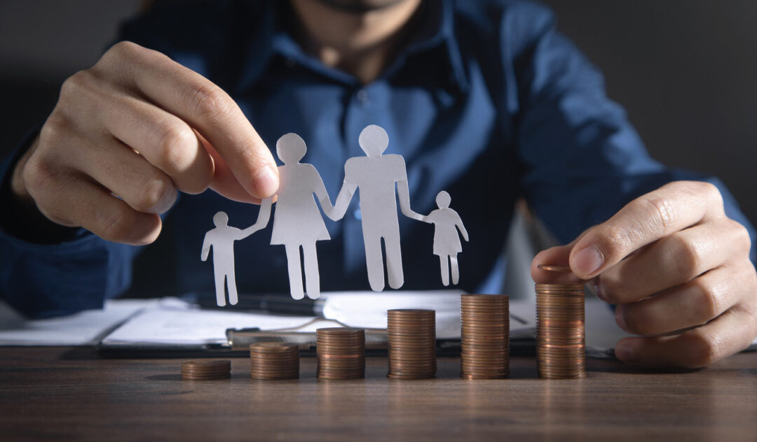 Man with a paper family and stack of coins.