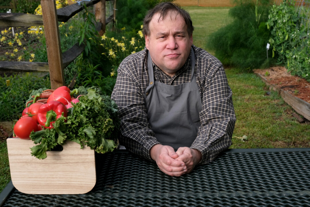 Autistic man spends time learning how to tend to a garden and collecting vegetables.