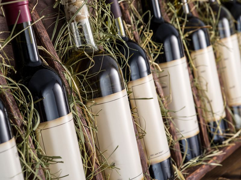 Wine bottles on the wooden shelf.