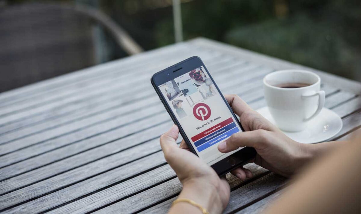 Woman holding a cellphone with the pinterest app open