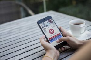 Woman holding a cellphone with the pinterest app open