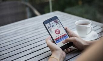 Woman holding a cellphone with the pinterest app open