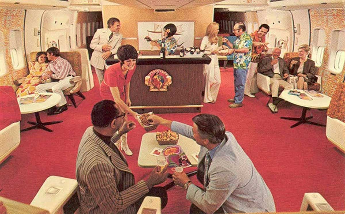 Men getting served snacks in the bar area of an airplane in the 1970s