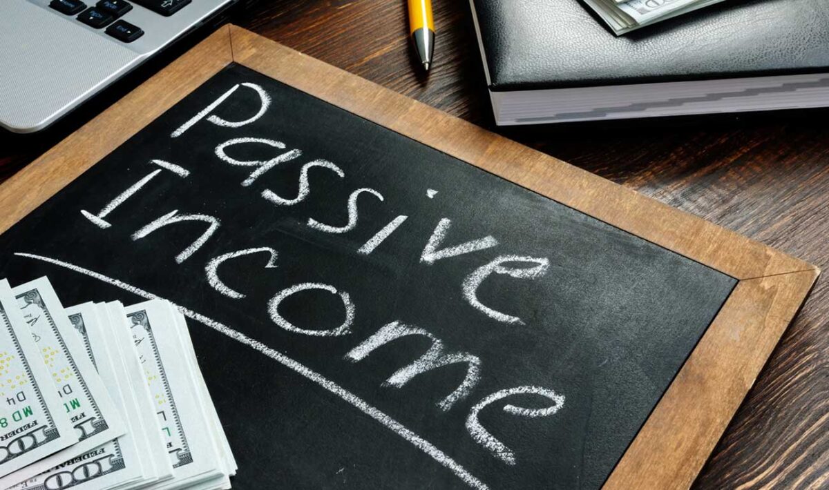 The words passive income written on a small blackboard sitting on a desk