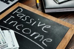 The words passive income written on a small blackboard sitting on a desk