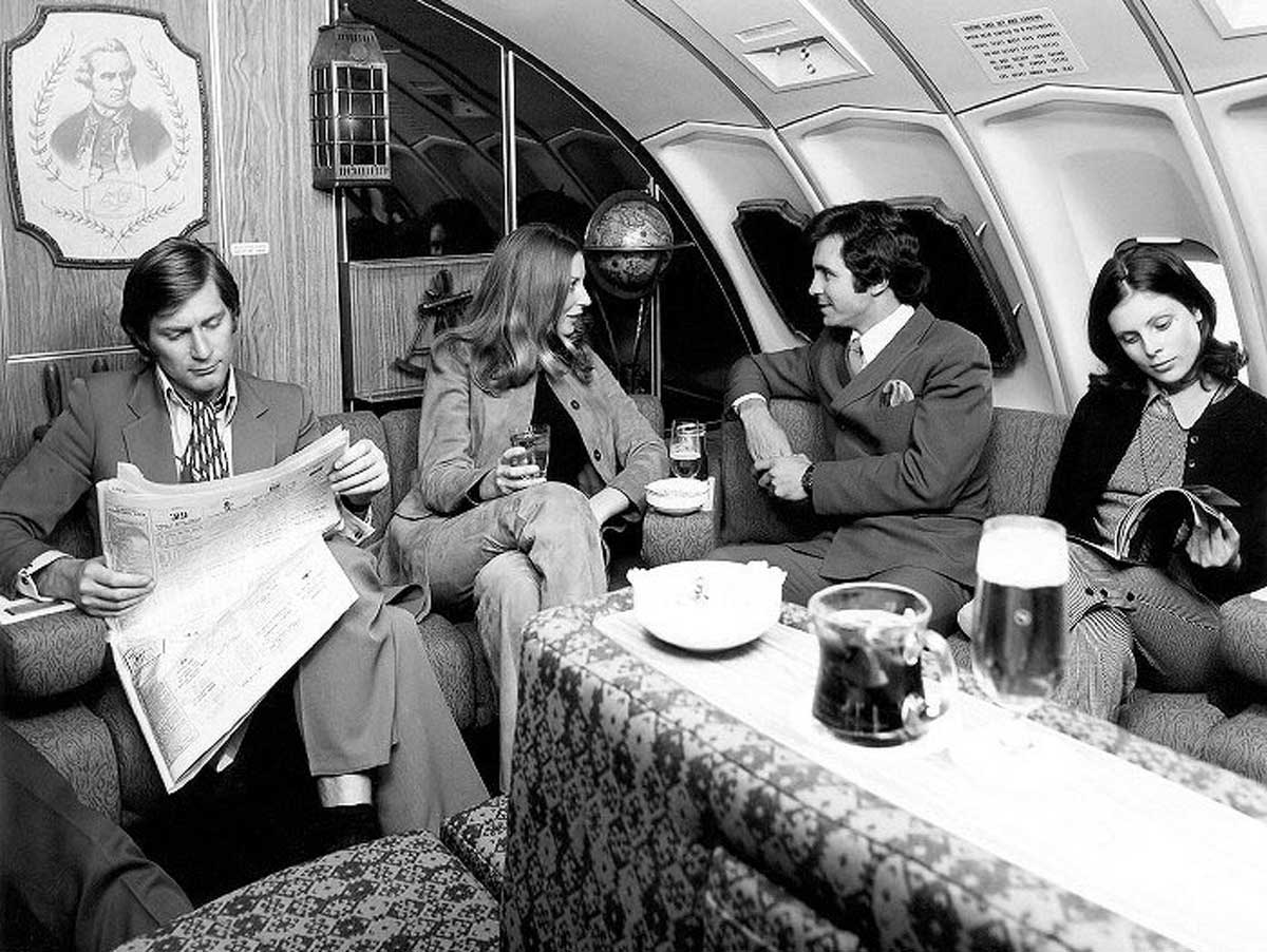 4 people relaxing in the lounge of a 1970s flight