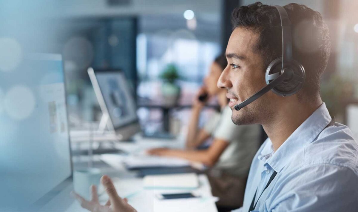 Man with a head set looking at a computer screen