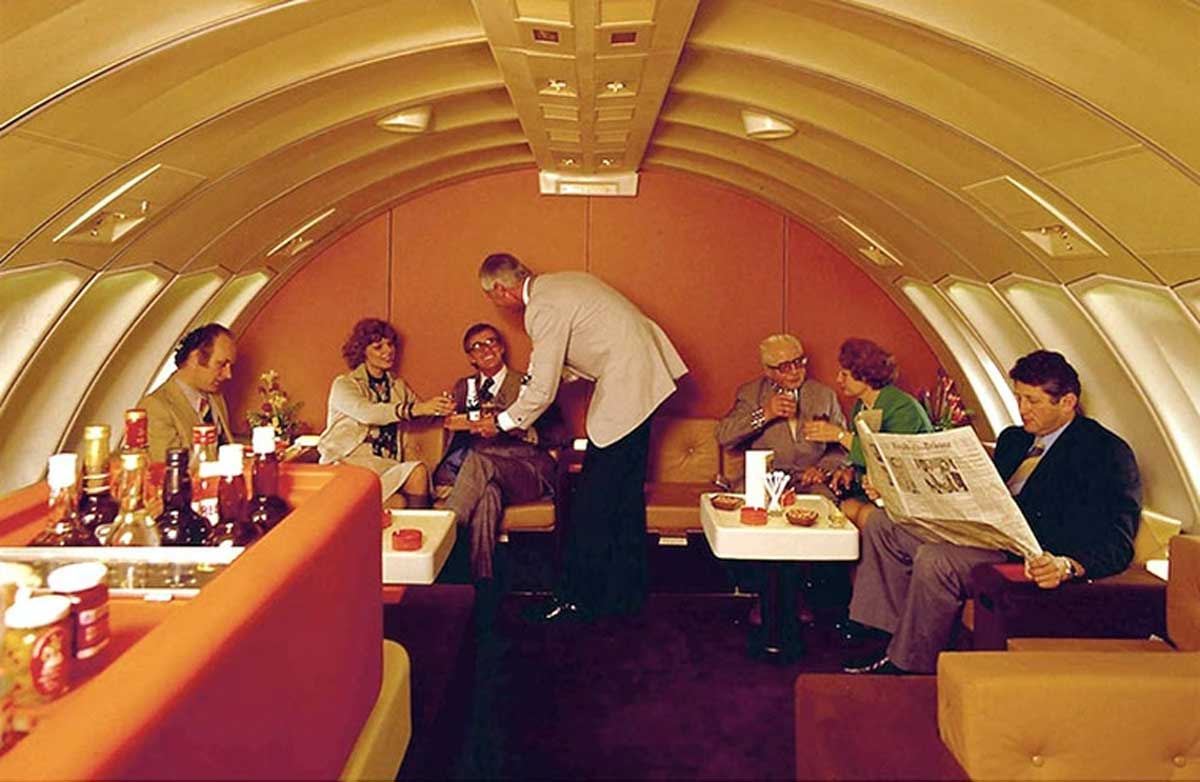 People relaxing in the lounge of a luxury flight in the 70s