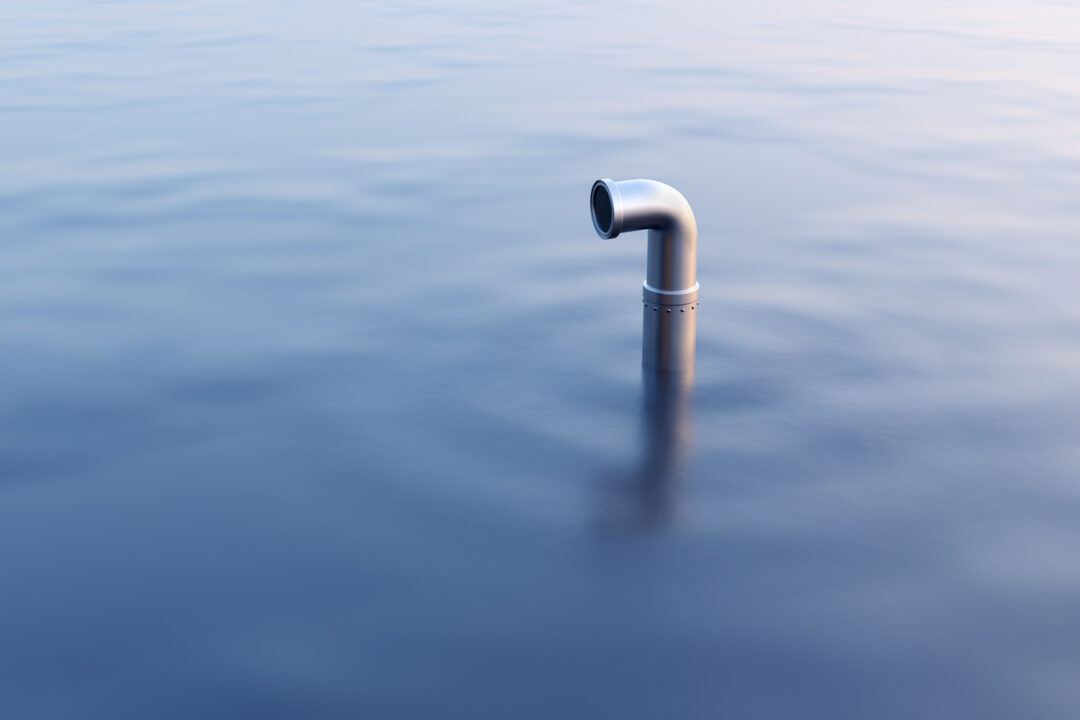 Silver periscope popping out from the undersea at sunset