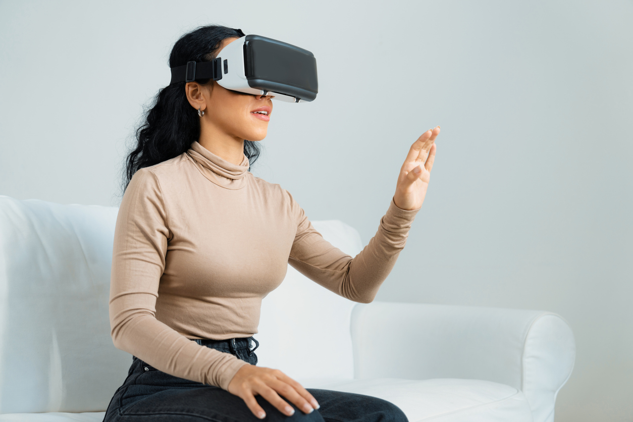 Young woman using virtual reality VR goggle at home for crucial experience