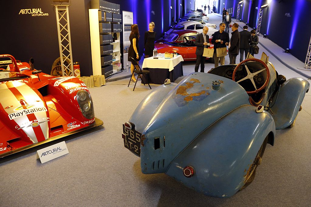 People stand next to a Bugatti Type 13 "Brescia", circa 1925, on display at the Artcurial auction house in Paris on June 20, 2015. The cars will be auctioned off on June 22, during the 8th edition of the sale entitled "Automobiles Sur Les Champs". AFP PHOTO / FRANCOIS GUILLOT        (Photo credit should read FRANCOIS GUILLOT/AFP via Getty Images)