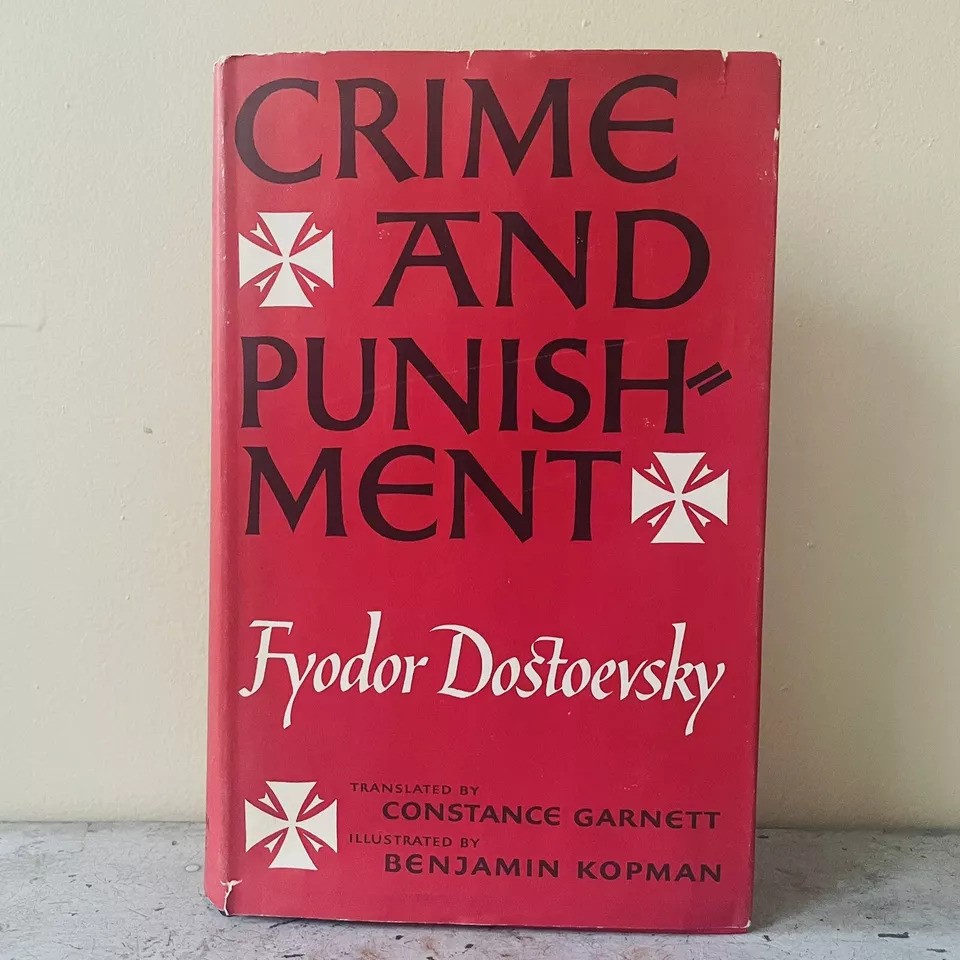 A red book cover featuring the title "Crime and Punishment" by Fyodor Dostoevsky, translated by Constance Garnett and illustrated by Benjamin Kopman. The design includes decorative cross-like symbols.