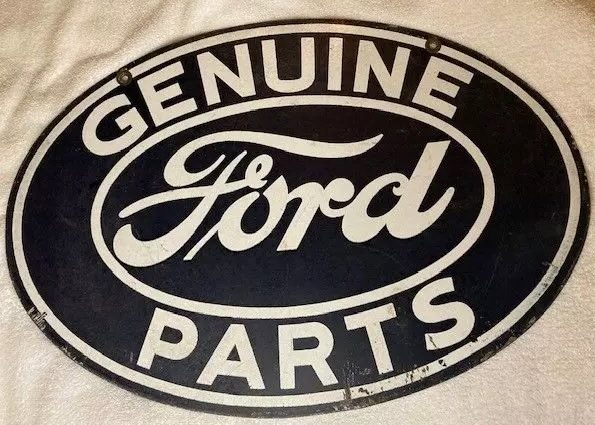 A vintage oval sign with a black background and white text reads "Genuine Ford Parts.