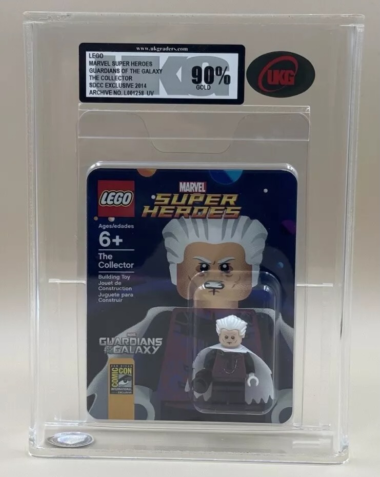 A collectible LEGO figure of "The Collector" from Marvel's Guardians of the Galaxy is encased in packaging. The display box shows a 90% grade label. The figure and packaging include branding for LEGO, Marvel, and Comic-Con.