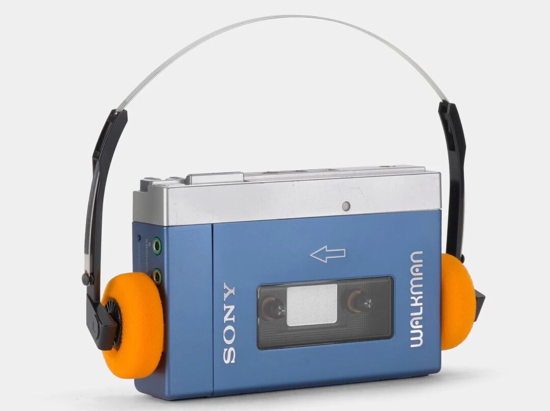 A vintage blue Sony Walkman cassette player with black and orange foam headphones attached via a thin metal band, shown against a plain background.