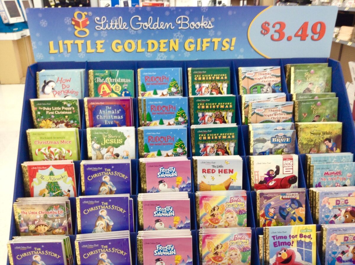 Display of Little Golden Books featuring various holiday-themed titles, such as "The Christmas Story" and "Rudolph the Red-Nosed Reindeer," priced at $3.49 each. The sign above reads “Little Golden Gifts!”