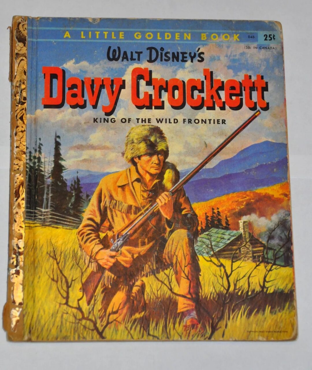 Cover of "Walt Disney's Davy Crockett: King of the Wild Frontier" from A Little Golden Book series. It shows a pioneer in buckskin clothes holding a rifle, with an autumn landscape, a cabin, and mountains in the background.