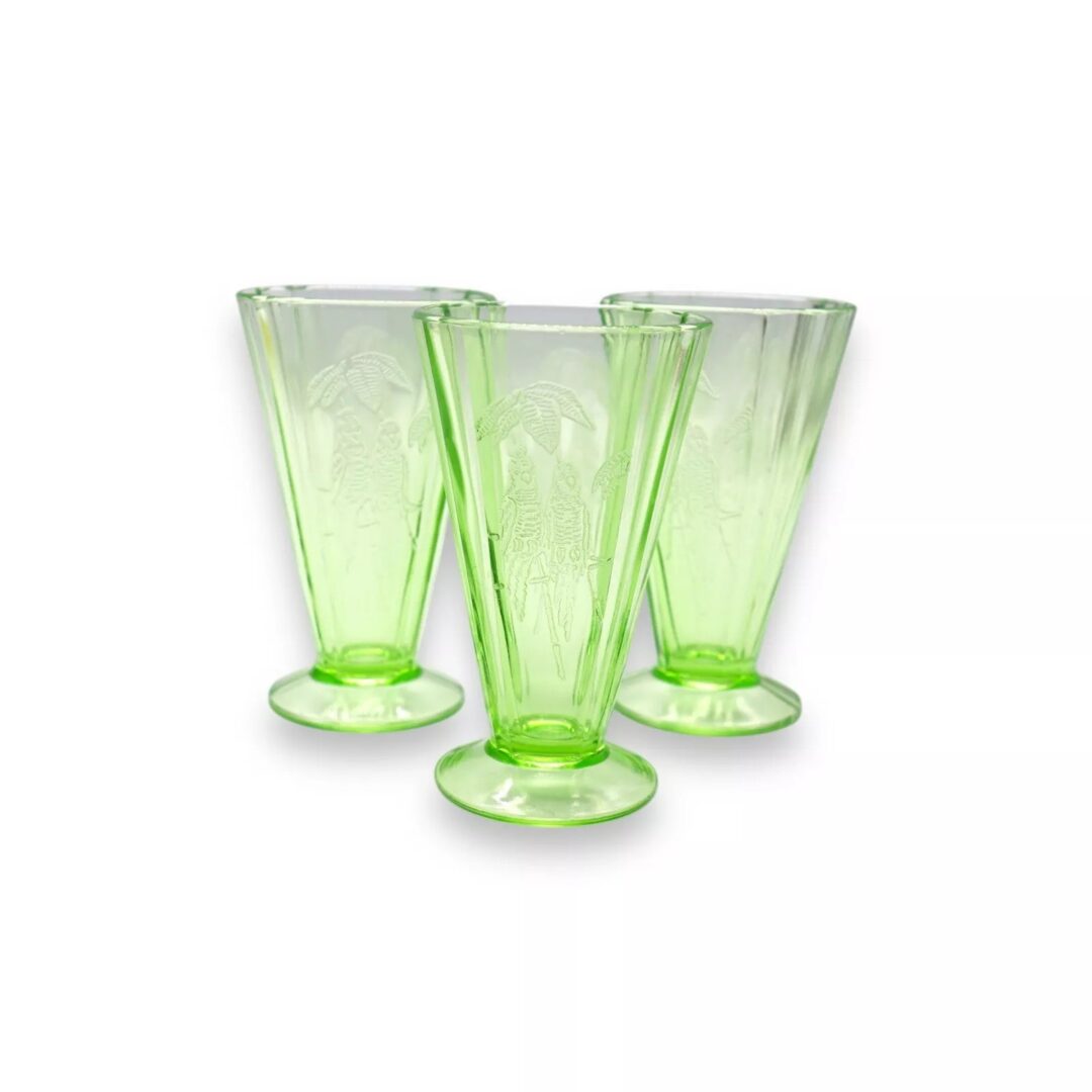 Three vintage green glass vases with etched designs featuring elegant, elongated figures. The glass is translucent and has a subtle, intricate pattern. The vases are placed against a plain white background.