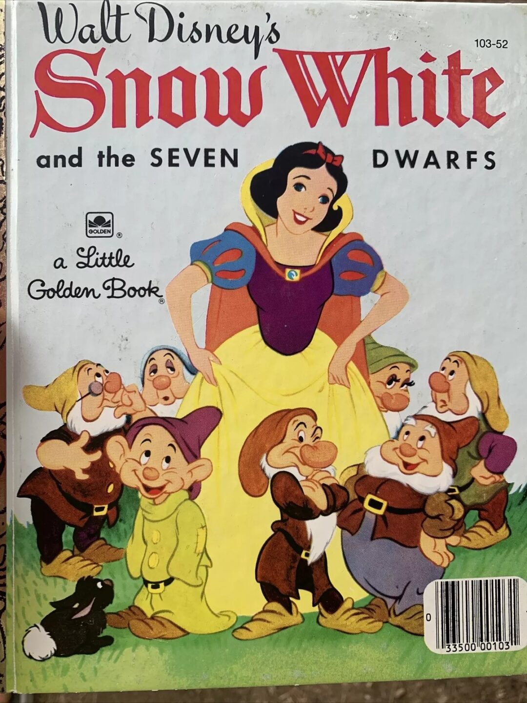 Cover of "Walt Disney's Snow White and the Seven Dwarfs" Little Golden Book. Snow White stands surrounded by the seven dwarfs, each with a distinct expression. The title is at the top, and there's a barcode at the bottom right.