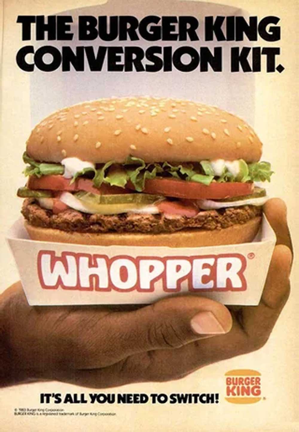 A hand holds a Burger King Whopper in a paper tray. The text reads “The Burger King Conversion Kit” at the top, with “WHOPPER” and “It’s all you need to switch!” at the bottom next to the Burger King logo.