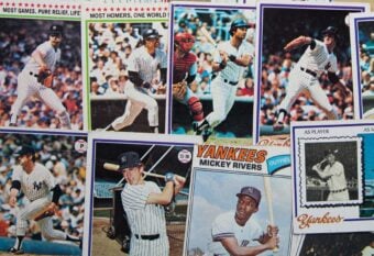 A collection of vintage New York Yankees baseball cards featuring players in various batting and fielding poses, with some cards overlapping each other.