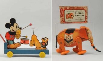Two vintage tin toys: on the left, Mickey Mouse pulls Pluto on a wheeled platform with a drum; on the right, an orange elephant with a raised trunk stands by a "Jumbo Bak-Up" box.