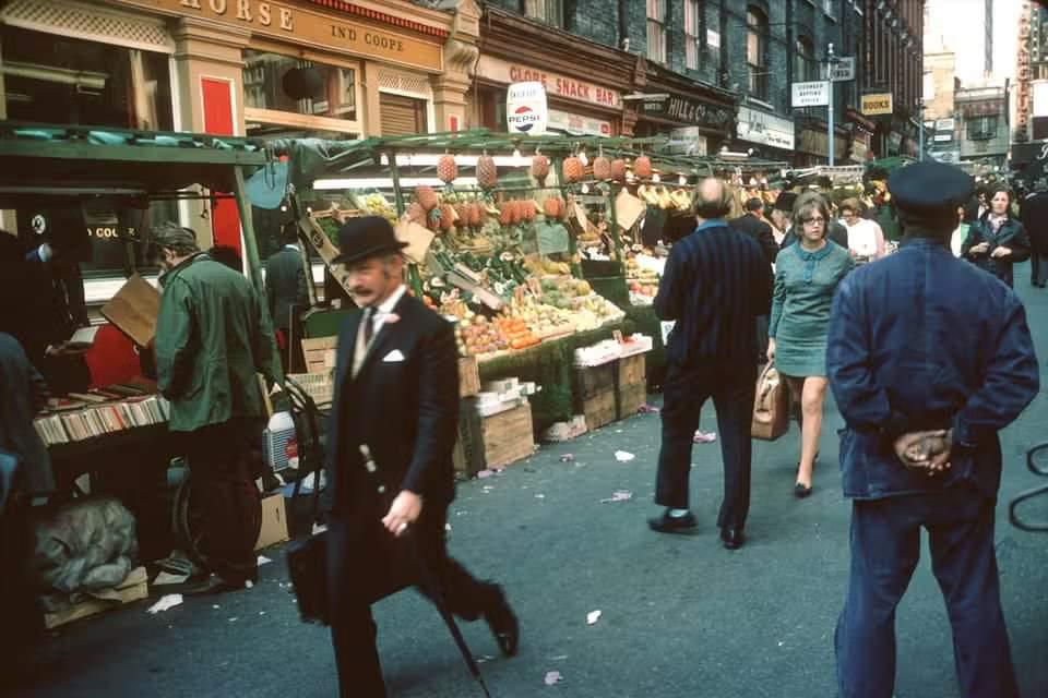 man walking through a street market in soho, london