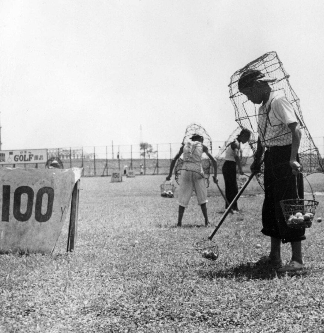 kids in japan wearing cages to fetch golf balls at the driving range