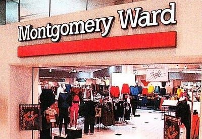 The entrance of a Montgomery Ward store in a shopping mall, with clothing racks and displays visible inside under bright lighting.